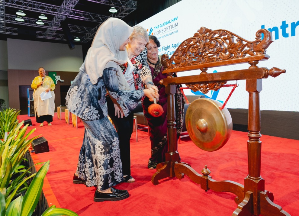 Three presenters hitting a gong to signal the start of the consortium